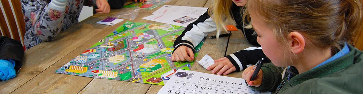 Kinderen zijn tijdens het detective kinderfeestje bezig met het onderzoeken van het bewijsmateriaal.